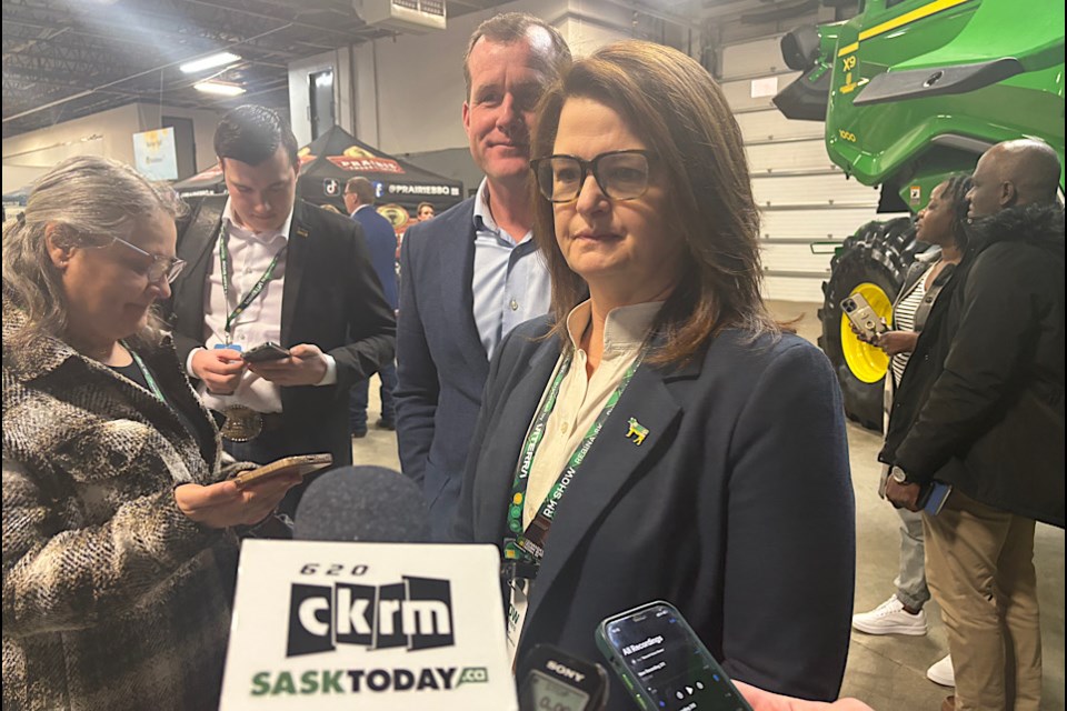 Opposition Leader Carla Beck, along with Trent Wotherspoon, speaks to reporters at Canada’s Farm Show.