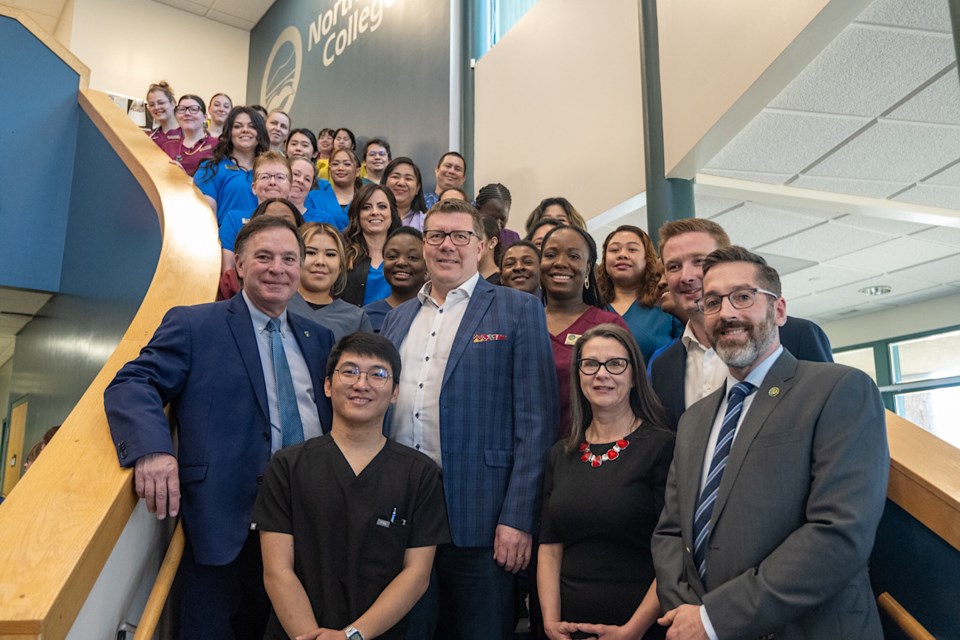 Premier Scott Moe, Minister of Advanced Education Gord Wyant, and others on the stairs at North West College.