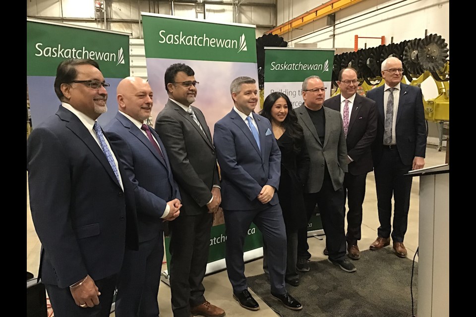 Dignitaries are all smiles at an event at Degelman Industries in Regina marking a new record population for Saskatchewan.