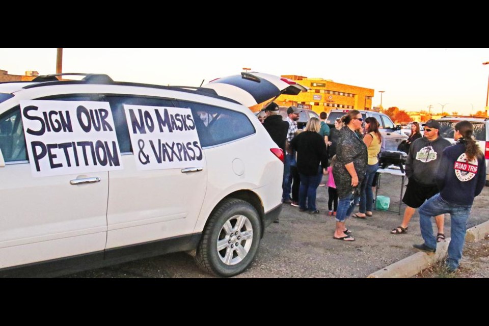 WIth signs inviting people to sign their petition, a tailgate protest party was organized by Weyburn's "We Are Free" movement, opposing vaccine passports and COVID vaccinations.