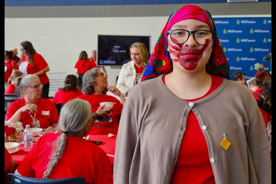 Rainbow Watchmaker wears a handprint symbolizing the Missing and Murdered Indigenous Women and Girls during the Red Dress Day Walk on Monday, May 5, at the Saskatoon Police Service.