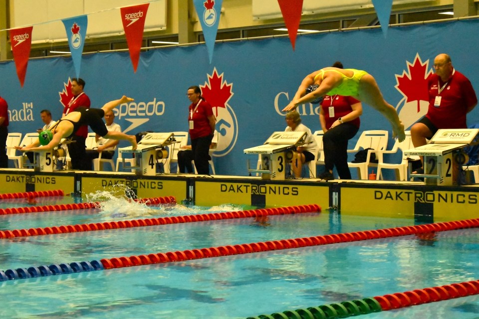 Female swimmers dive into the pool to begin the first 16 laps in an 800-metre freestyle event in the 2025 Speedo Masters National Championships at the Shaw Centre.