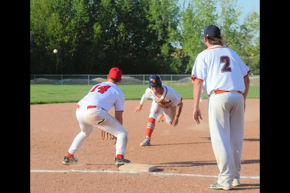 Beaver Connor Neave is about to dive for the base, while Cardinals’ third baseman Rob Cey waits for the ball to arrive. Cey was able to tag Neave before Neave’s hand touched the base, but Beavers still won the game 9-3 to clinch the NSRBL championship. Looking on is Bryce Gatzke of the Beavers.