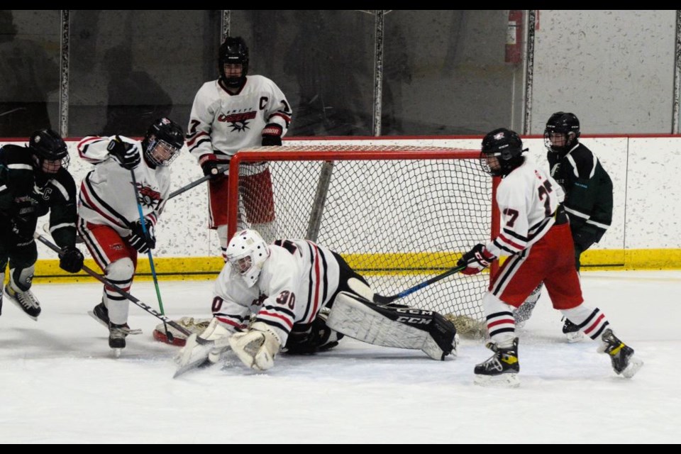 Unity goalie Noah Gumpinger reaches for the puck in a save during U15 provincial action in Unity Feb. 12. featuring the National Outlaws and Unity Lazers. 