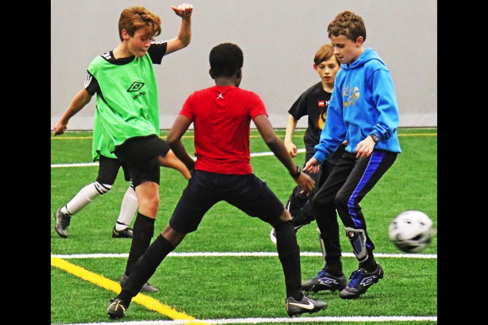 A green team player was able to kick the ball away from three of his opponents, during the U13 boys practice on Thursday night for Weyburn Minor Soccer.