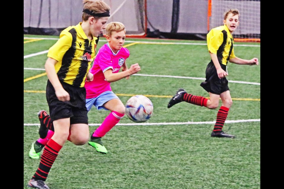 Weyburn U13 player Ranson Jordens, left, ran with the ball up the field during a game vs FC Regina on Saturday, with teammate Ethan Thiedig at right.