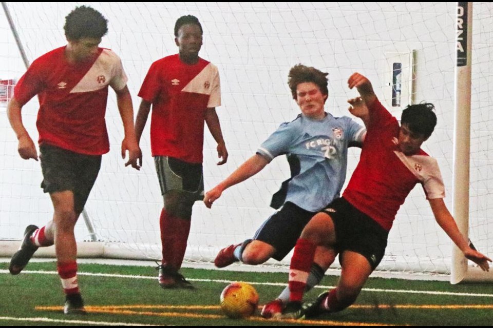 Players from FCR Regina, in blue, and Forge FC, in red, battle for the ball at an evaluation camp on Sunday in Weyburn