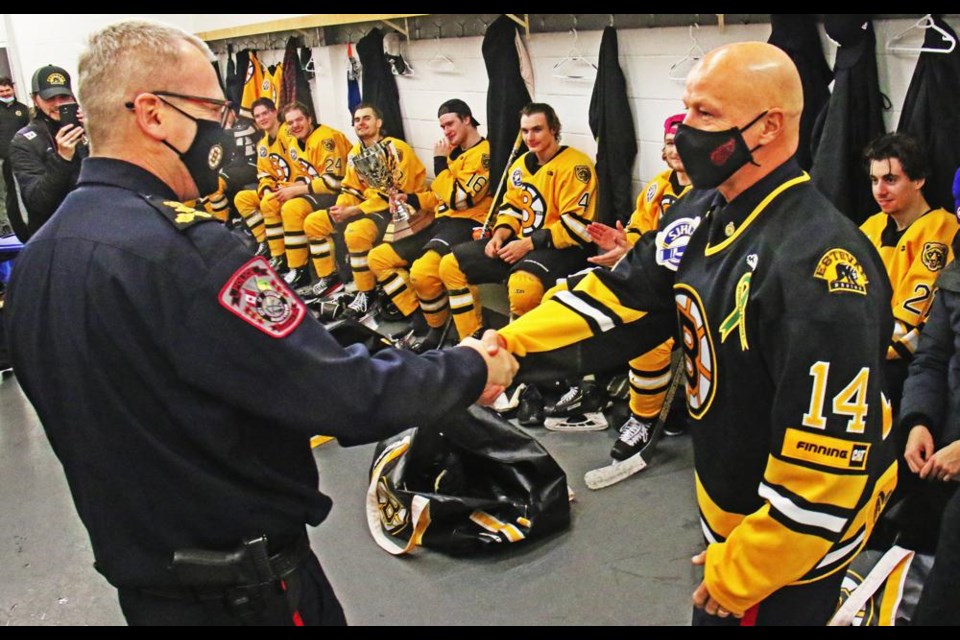 Weyburn police chief Jamie Blunden, right, shook hands with Estevan police chief Richard Lowen after donning the Bruins jersey. The two police chiefs presented the Highway 39 Cup trophy to the Bruins after they swept the Wings two games straight.