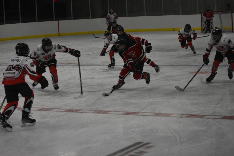 A Canora Cobra (dark jersey) rushed towards the Kamsack Flyers goal.