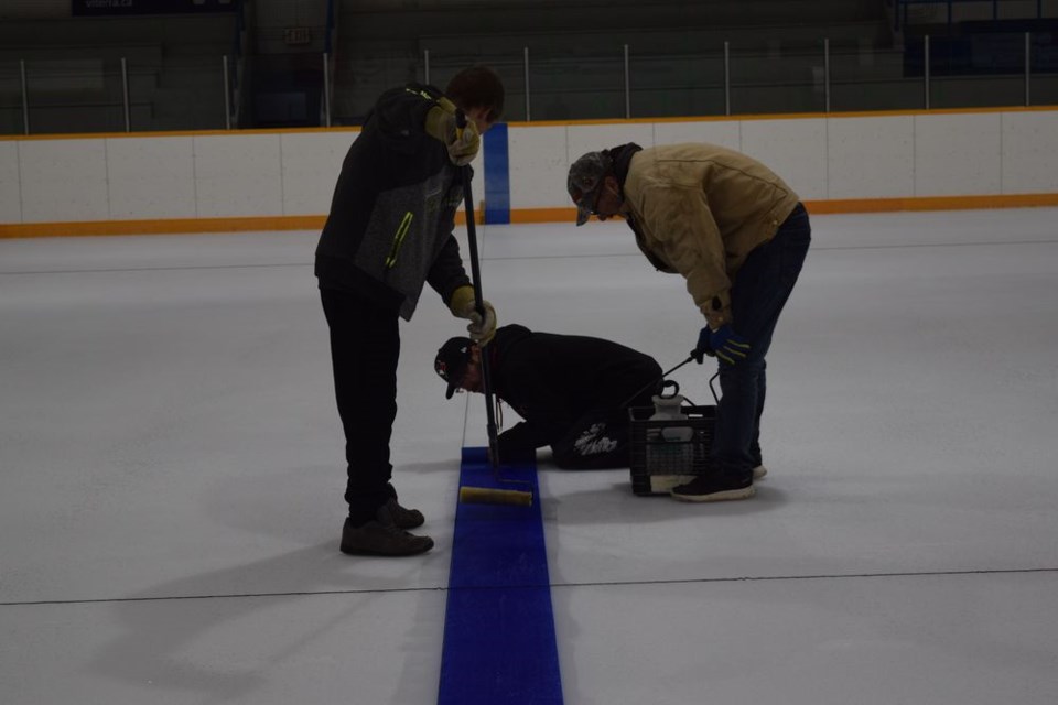 On October 20, lines were being put in place on the newly-installed ice at the Canora Civic Centre in preparation for the upcoming hockey season. Working on the blue line, from left, were: William Jordan, Graham Lamb, and Kevin Haw. / Rocky Neufeld