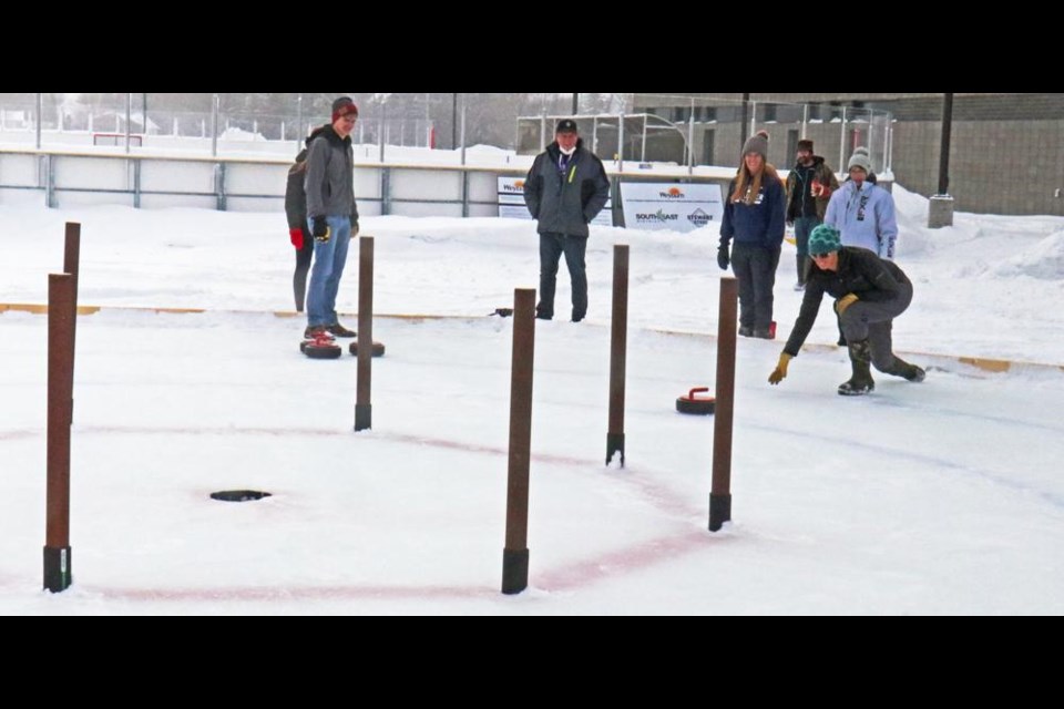 Jodi Long of the Weyburn Ag Society, at right, threw a rock as spectators watched, during a demonstration on Saturday of the game of Crokicurl at Weyburn's CU Spark Centre