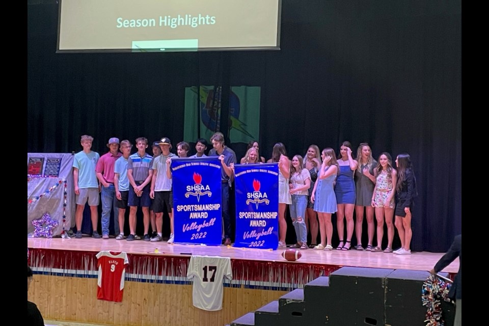 Volleyball players gather with their sportsmanship banners at the ECS athletics awards.