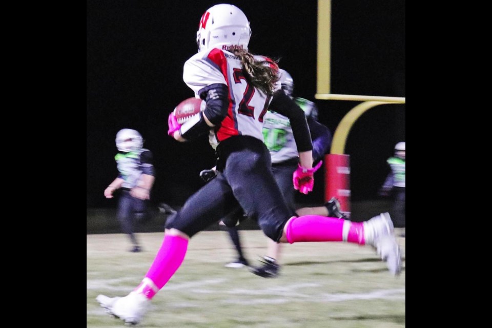 Weyburn athlete Ella Schenher is shown running with the football, a sport where she won the U14 Offensive MVP award for the Moose Jaw Minor Football League