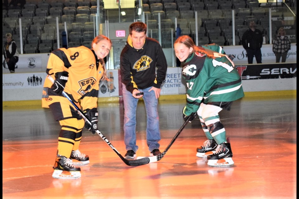 Brad Durr, middle, dropped the puck for the ceremonial opening faceoff for Chelsey Madsen (8) of Estevan and Avery Moore (17) of Saskatoon. 