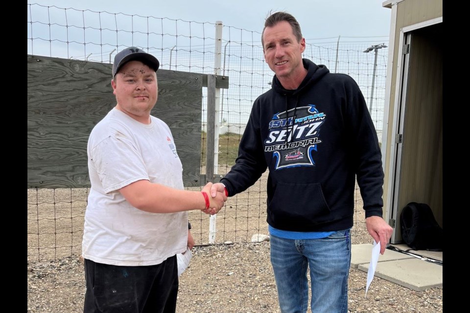 Dallas Wanner, left, accepts top prize from Estevan Motor Speedway president Brad Pierson. 