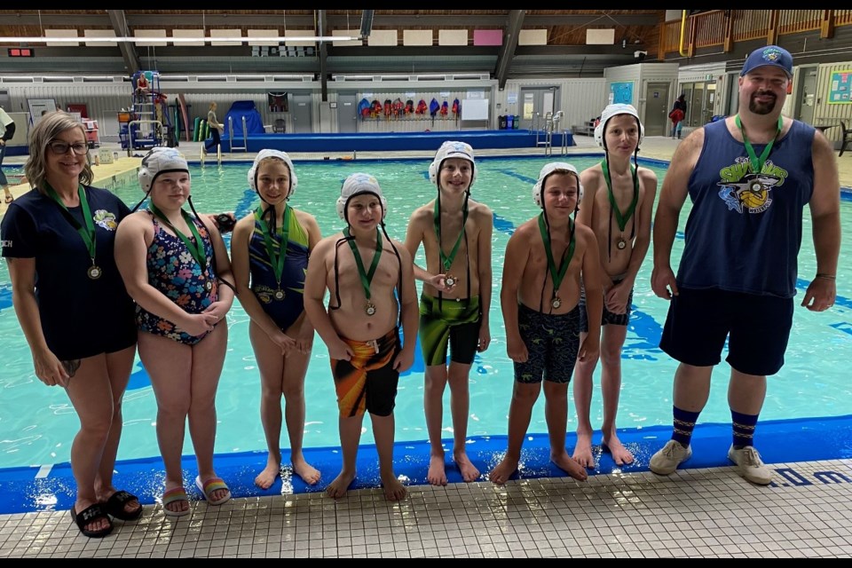 Estevan Sharks Minis with their gold medals are, from left, coach Kristy Jones, Ayla Smelt, Rosalie Horrocks, Jaxson Ward, Jaxon Reinhardt, Eoin Jones, Eli Sclear and coach Alan Smelt.