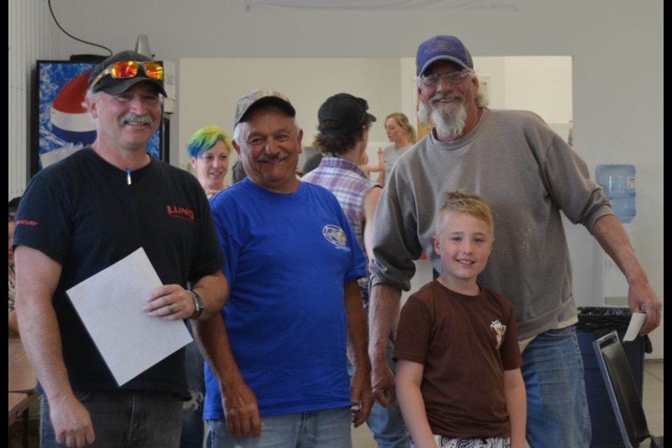 Mike Halirewich presents the top prize to Clinton Harkins and Darcy Dukart. Also in the photo is volunteer Rowan Jassen.