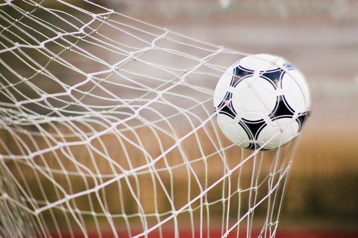 football trapped in a goal net