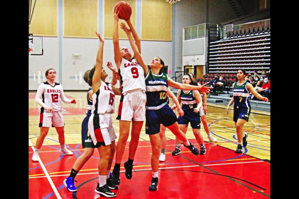 WCS Eagles player Skyler Kreger reached high for the rebound during a play against Regina WInston Knoll on Friday.