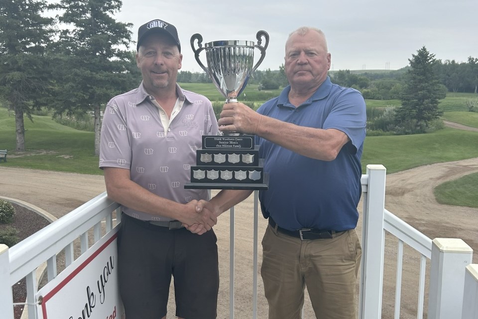 Rick Hallberg, left, accepts the senior championship trophy from Don Hilstrom.