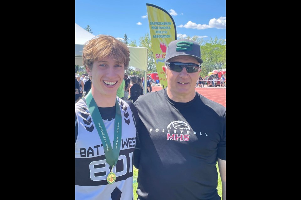 Isaiah Mamer, flagged by McLurg principal and his dad Greg Mamer, with one of his three gold medals won at provincial track and field.