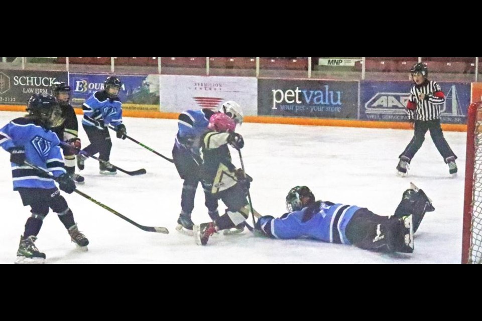 A Jr. Gold Wing player tried to get to the puck as the Regina Diamonds goalie sprawled to cover it up, during exhibition play on Saturday at Crescent Point Place.
