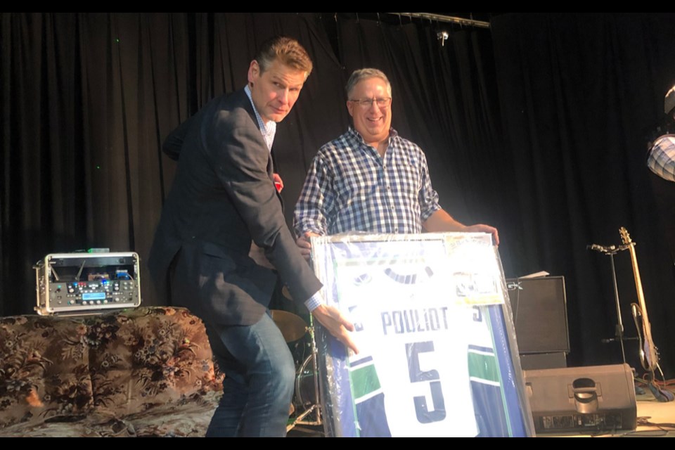Guest speaker Stu Grimson, left, and Blake Fornwald - a Lampman recreation board member and RM of Browning Councillor - with a Derrick Pouliot jersey that was auctioned off. Pouliot, a former Lampman resident, has played in the NHL.