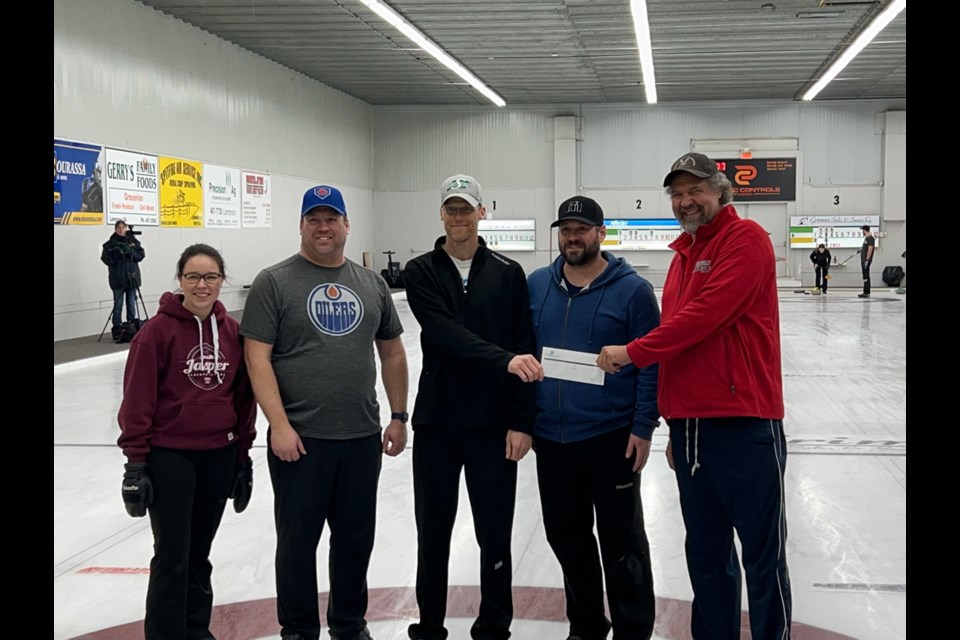 The winners of the A event in the 64-rink Lampman bonspiel were, from left, Taylor Marcotte, Kirk Himmelspach, Ryan Hanrieder and Adam Himmelspach. Calvin Christensen, the president of the Lampman Curling Club, presented the prize. 