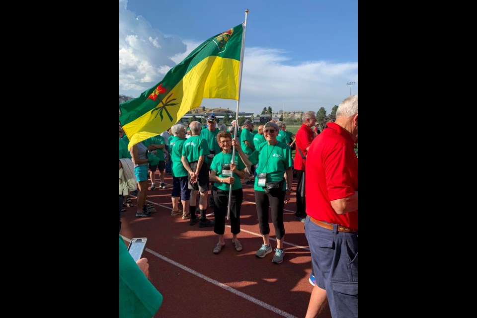 Cut Knife athlete, Mary Ramsay, stands with the Saskatchewan flag before opening ceremonies of Canada 55+ games held in Kamloops.