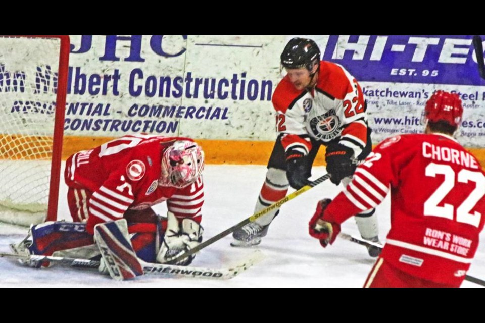 Red Wings goalie Dazza Mitchell covered up the puck as Yorkton player Zach McIntyre dug in with his stick in the hopes of getting the puck loose
