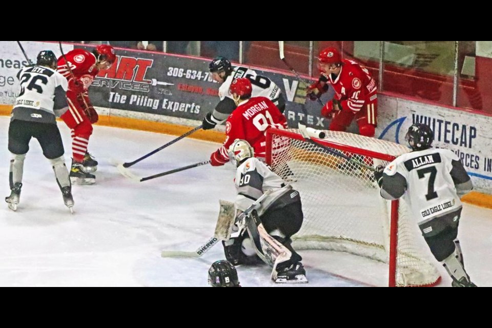 Red Wings players Jackson Hassman, Ryley Morgan and Ty Mason go after the puck by the side of the North Battleford net.