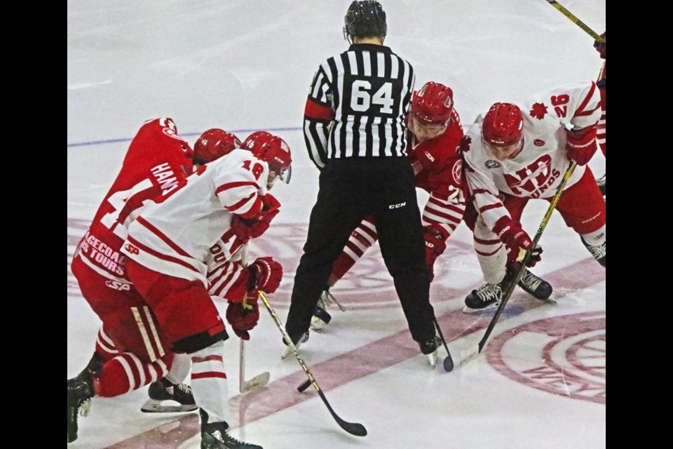 Players for the Weyburn Red Wings and Notre Dame Hounds battle for possession of the puck at the opening faceoff on Saturday