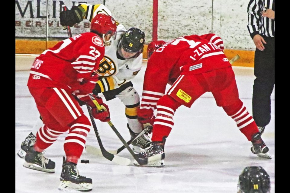 Red Wings players Ethan Whillans and Davis Chorney battle for the puck along with an Estevan Bruins player in a faceoff in the Bruins end.