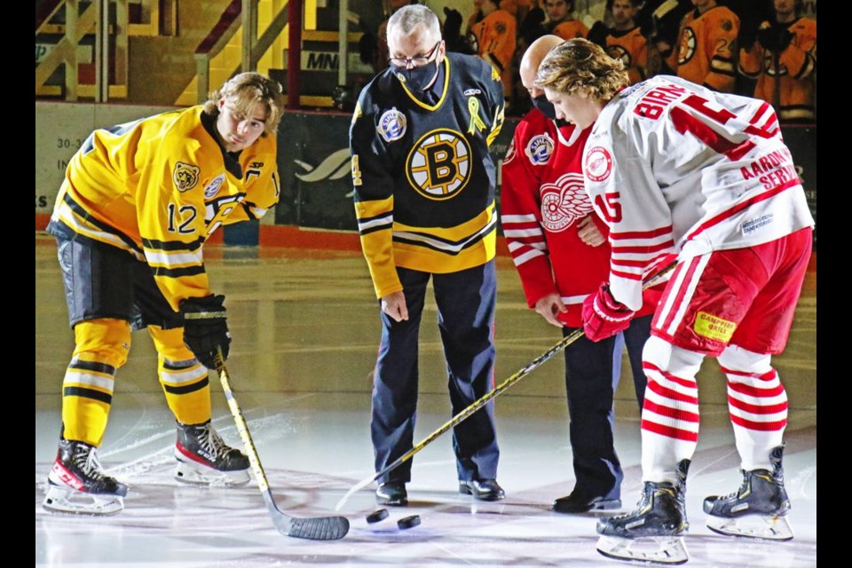 Estevan captain Eric Houk, left, and Weyburn captain Braden Birnie, right, took part in the ceremonial puck drop for the Highway 39 Cup game in Weyburn on Saturday night, with Estevan police chief RIchard Lowen and Weyburn police chief Jamie Blunden doing the honours at centre ice.