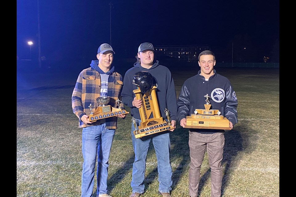 Seen here are Layne Watts, Michael Michnik and Jackson Geddes receiving high school football awards.