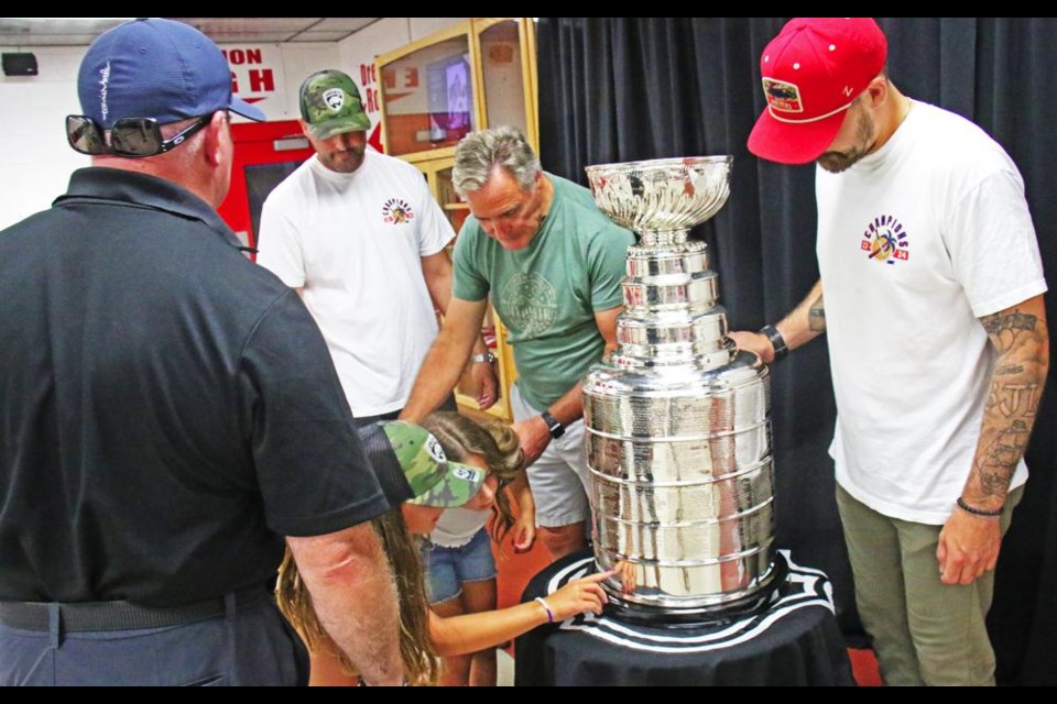 Keira and Kate Jackson look at the name plate on the Stanley Cup, and points to her grandfather's name, Les Jackson. Her uncle Reid Jackson and Les both work for the Panthers, and brought the Stanley Cup to Weyburn for fans to see.