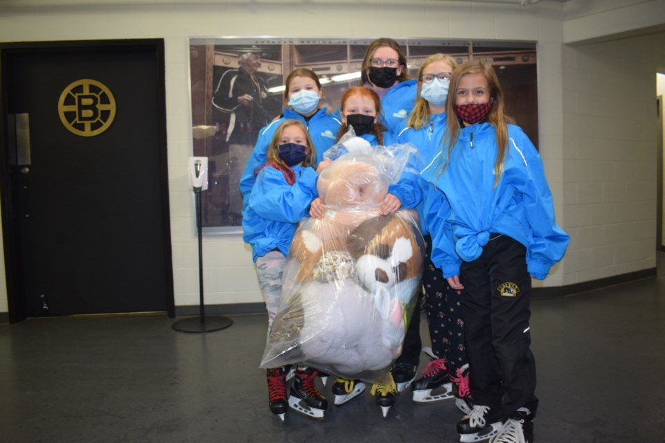 Members of the Estevan Senchuk U11 Bearcats 1 and 2 teams hold a big bag of teddy bears.
