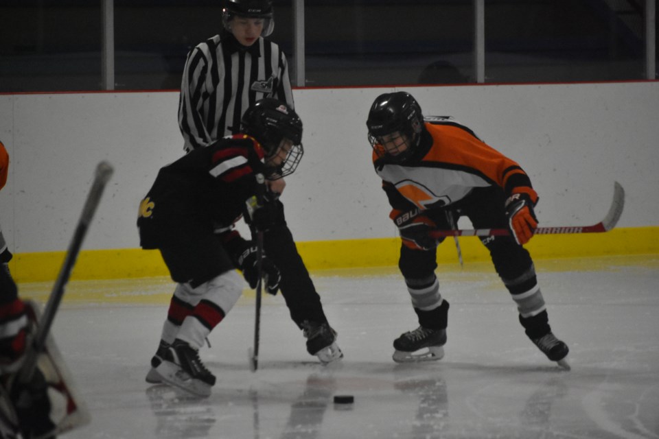 A Yorkton Terrier and a Kamsack Flyer faced off one-on-one to secure the puck for their team.