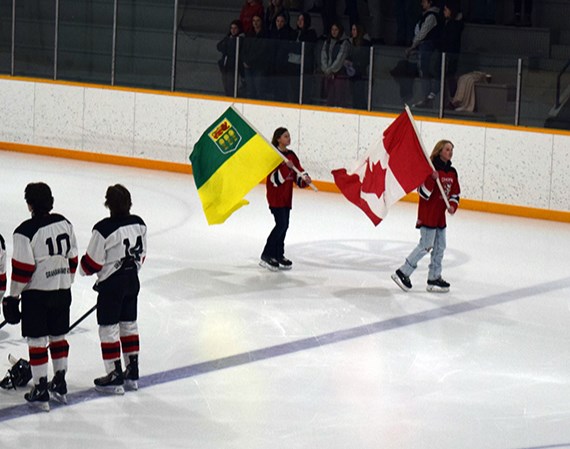 Flag bearers circling the Canora Civic Centre with the Canadian and Saskatchewan flags prior to Game 2 of the second round of provincials between the U18 Canora Cobras and the visiting Cupar Canucks were Courtlyn Heshka (Canadian flag), a member of the U13 Canora Cobras, and Cassidy Wolkowski (Saskatchewan flag), a member of the U15 Highway 9 Predators and the U15 Parkland Prairie Ice female team.  