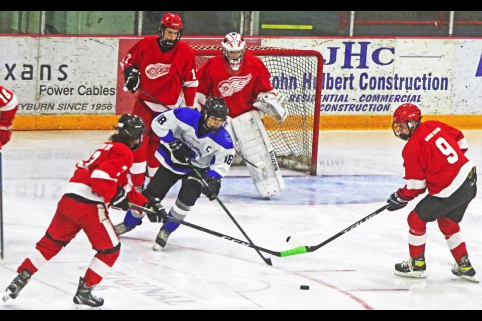 Weyburn U18 Wings Jyler Goebel, left, and Nate Peterson went after the puck along with a Swift Current Bronco in front of goalie Josh Wiens on Wednesday evening