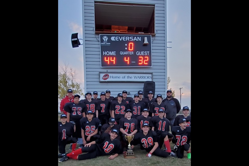 Unity Jr. Warriors pose proudly with the scoreboard after capturing a repeat league championship in Unity on Oct. 4.