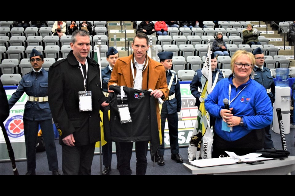 From left, Jeff and Brad Pierson accepted the volunteer jacket of their late mother Melodye from Allison Holzer. 