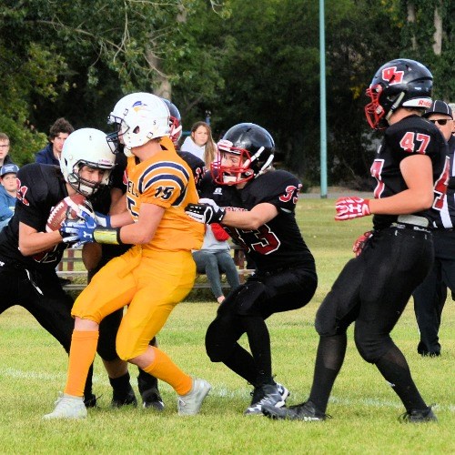 Returning a punt, Unity’s ball carrier Dax L’Heureux holds on tight to prevent Kerrobert’s Emery Cholin from stripping him of the ball. Assisting Dax are Jagr Lewin (hidden), Ethan Bertoia and Rylan Fauth.