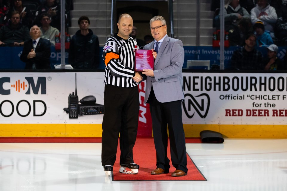 Chris Crich (left) receives the WHL Milestone Award from WHL Senior Director of Officiating Kevin Muench.