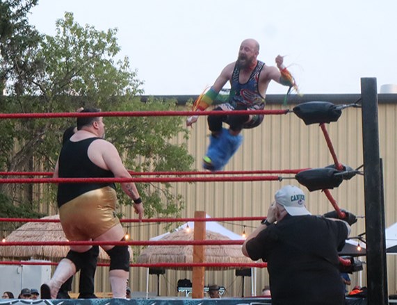 “The Audacity” Danni Deeds (airborne) fought hard to overcome a significant weight disadvantage against “The Boston Bruiser” Kevin O’Doyle, including this flying drop kick off the top of the corner post. But O’Doyle won by pin, aided by shady shenanigans from a couple of other wrestlers.
