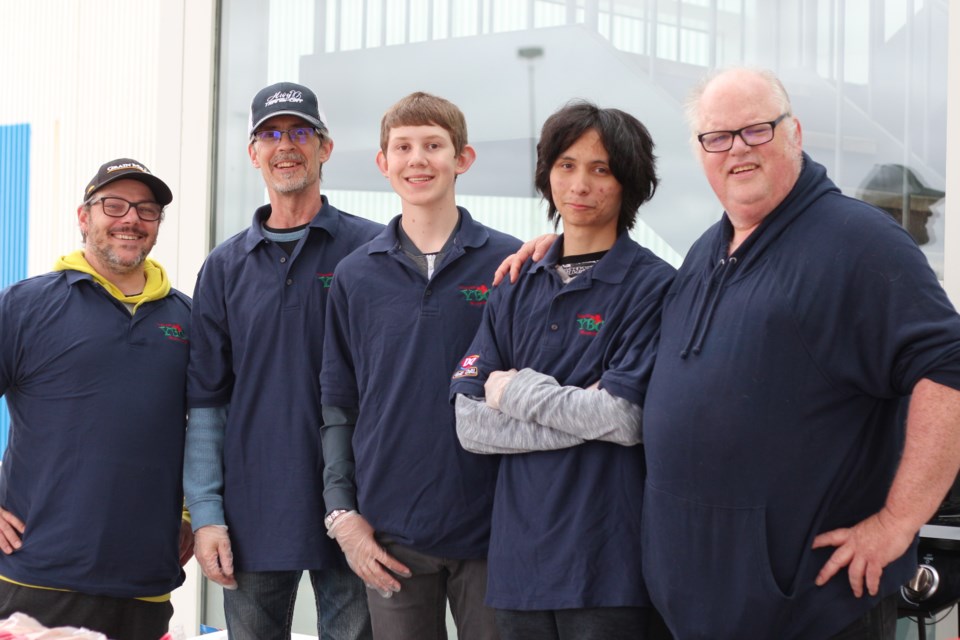 Noah Fortin (third from left) and Bronson Emery (second from right), pictured here with their parents and volunteers. The duo spent their Saturday selling hotdogs to raise funds for their trip to Oshawa to represent Saskatchewan in the YBC Nation Championships.