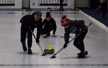 Josh Prychak, left, and Aidyn Tratch swept this shot by Paisley Wolkowski, who was watching intently and calling line.

