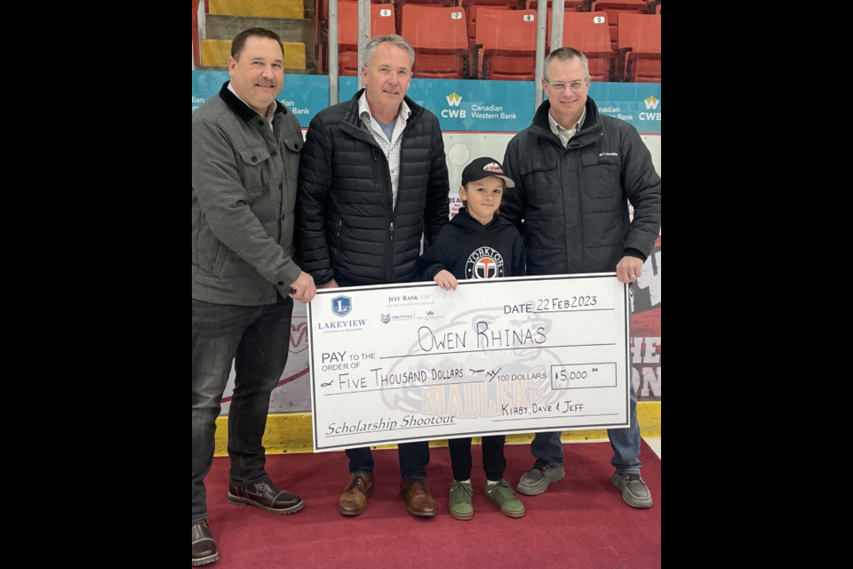 Pictured here, Jeff Rask, Dave Nussbaumer, Owen Rhinas and Kirby Stewart presenting a $5,000 scholarship cheque to the eight-year-old Rhinas.