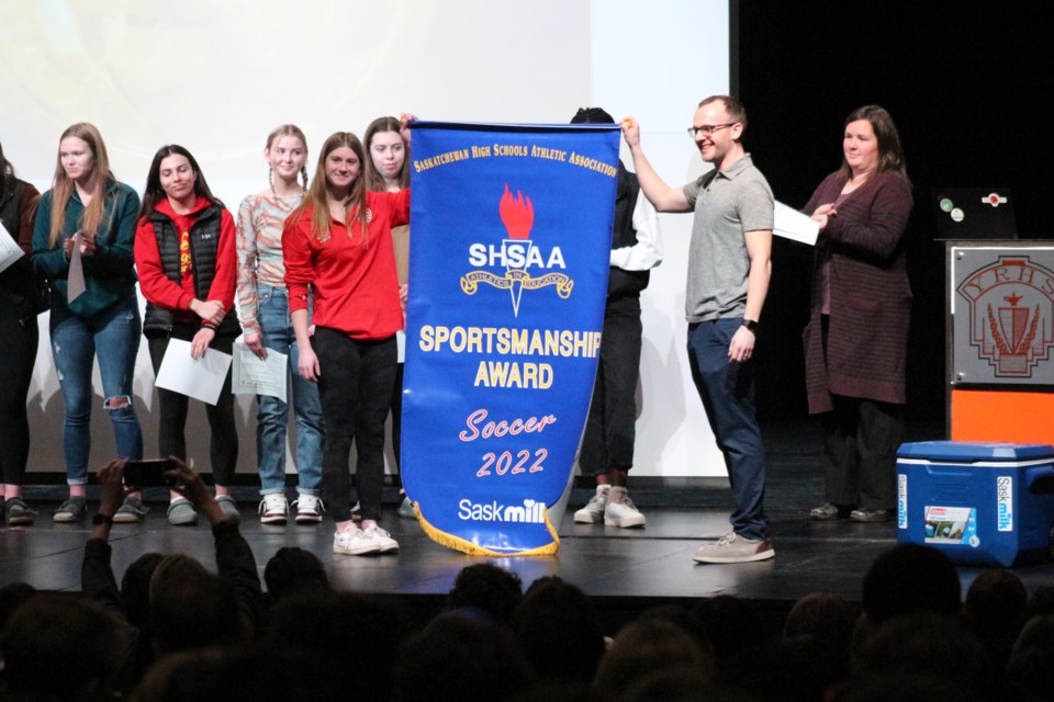 Student Isabelle Easton and Coach Mike Chapman unveil the banner recognizing the team's achievement.  This is the 6th blue banner the school has received for sportsmanship from the SHSAA.  