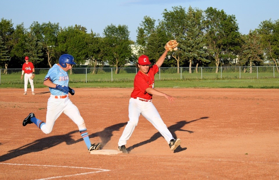 The tie goes to runner Matt Hudec during play in the first game of the championship series, in Wilkie July 28. Covering first base was Connor Ralston.